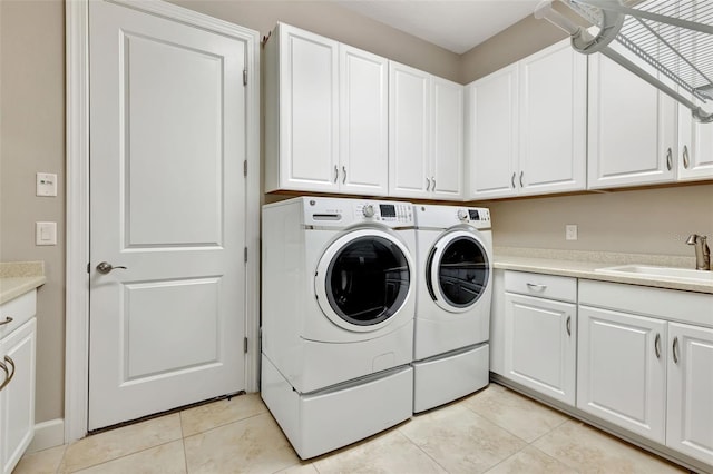 clothes washing area featuring cabinets, light tile patterned flooring, sink, and independent washer and dryer