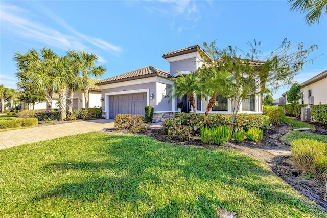 mediterranean / spanish house featuring a garage and a front yard