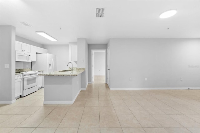 kitchen with white appliances, light stone counters, sink, white cabinetry, and light tile patterned flooring