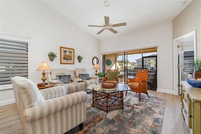 living room featuring light hardwood / wood-style floors, ceiling fan, and high vaulted ceiling