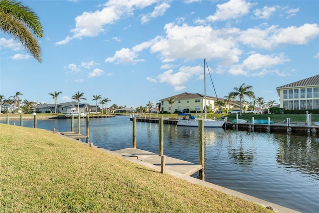 view of dock with a water view and a lawn