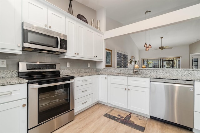 kitchen featuring light stone countertops, stainless steel appliances, white cabinets, ceiling fan, and sink