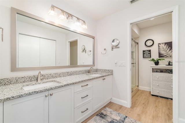 bathroom with vanity, a shower with shower door, and hardwood / wood-style flooring