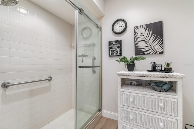 bathroom featuring hardwood / wood-style flooring and walk in shower