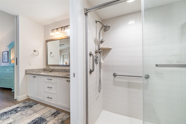 bathroom with an enclosed shower, vanity, and hardwood / wood-style flooring