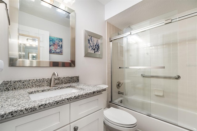 full bathroom with toilet, bath / shower combo with glass door, and vanity