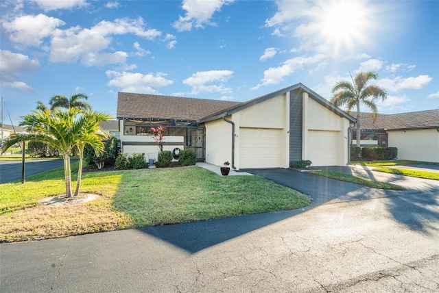 ranch-style house featuring a front lawn and a garage