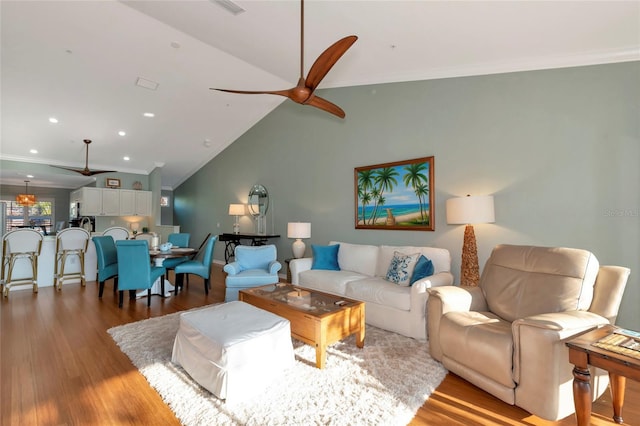 living room featuring vaulted ceiling, ceiling fan, crown molding, and light hardwood / wood-style flooring