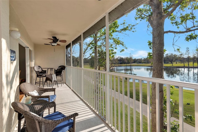 sunroom / solarium featuring ceiling fan and a water view