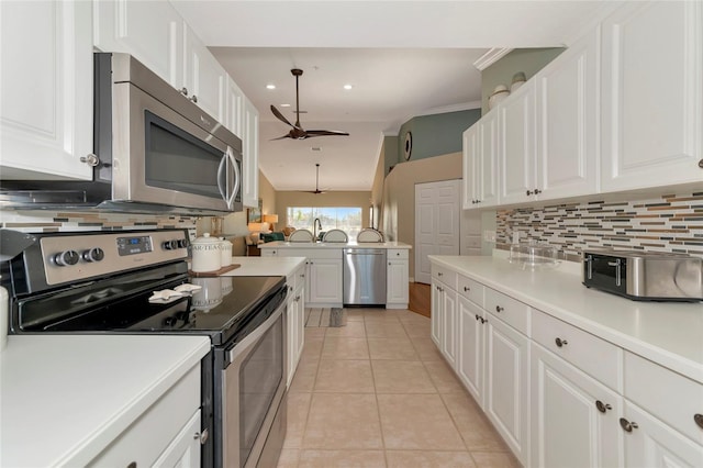 kitchen featuring stainless steel appliances, white cabinets, light tile patterned flooring, and ceiling fan