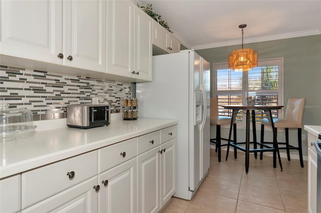 kitchen with white fridge with ice dispenser, hanging light fixtures, light tile patterned floors, white cabinets, and tasteful backsplash