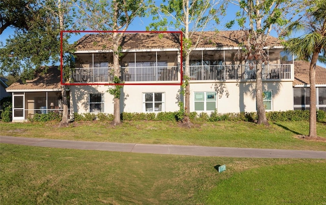 view of front of house featuring a front yard and a sunroom