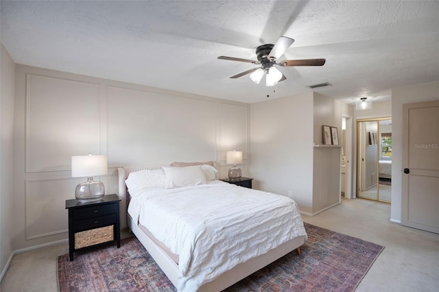 bedroom featuring carpet flooring, a textured ceiling, and ceiling fan