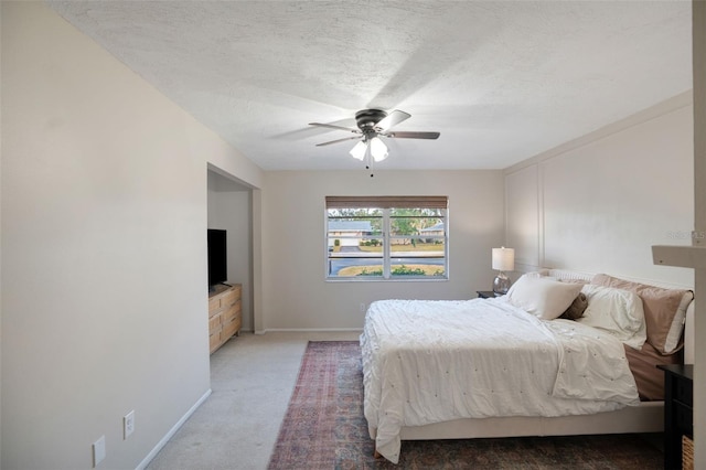 bedroom featuring ceiling fan, carpet, and a textured ceiling