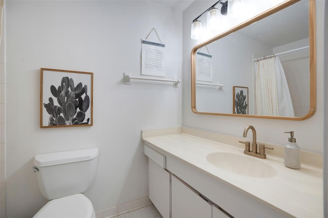 bathroom featuring toilet, tile patterned floors, walk in shower, and vanity