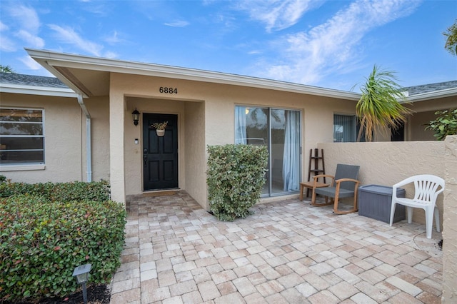 view of exterior entry with a patio