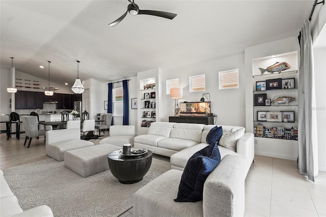 living room with ceiling fan, lofted ceiling, and light tile patterned floors