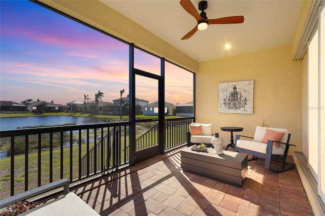 sunroom featuring a water view and ceiling fan