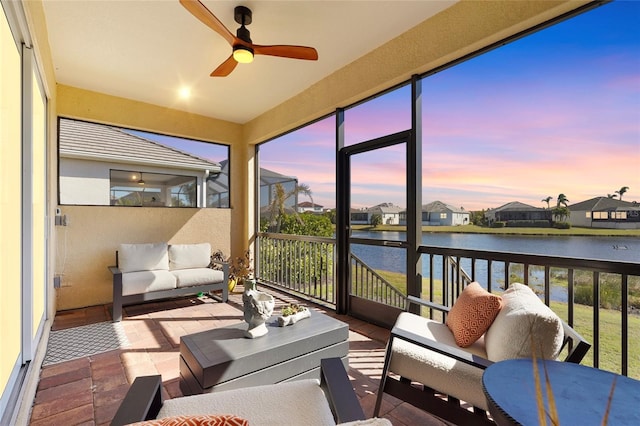 sunroom with a water view and ceiling fan