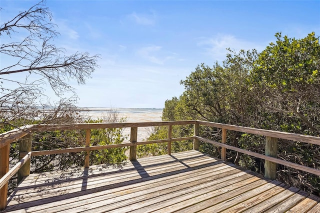 wooden deck with a view of the beach and a water view