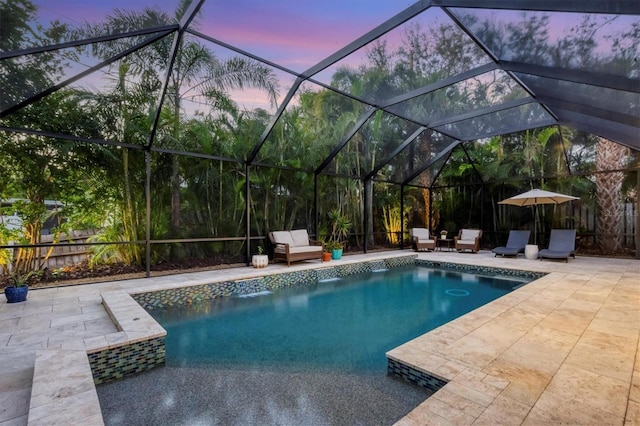 pool at dusk with a patio and glass enclosure