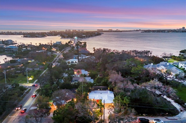 aerial view at dusk featuring a water view