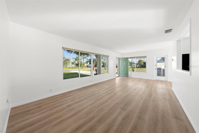 unfurnished living room featuring a healthy amount of sunlight and wood-type flooring