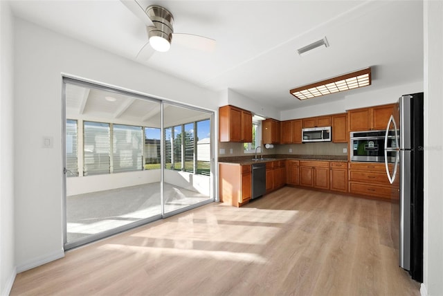 kitchen with stainless steel appliances, sink, ceiling fan, and light wood-type flooring