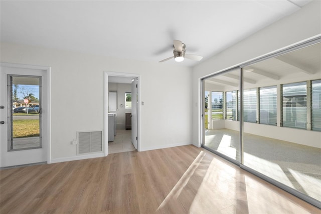 spare room featuring ceiling fan, light hardwood / wood-style floors, and a healthy amount of sunlight