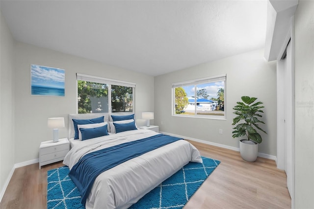 bedroom with wood-type flooring and multiple windows