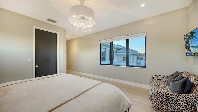 bedroom featuring a notable chandelier and light hardwood / wood-style flooring