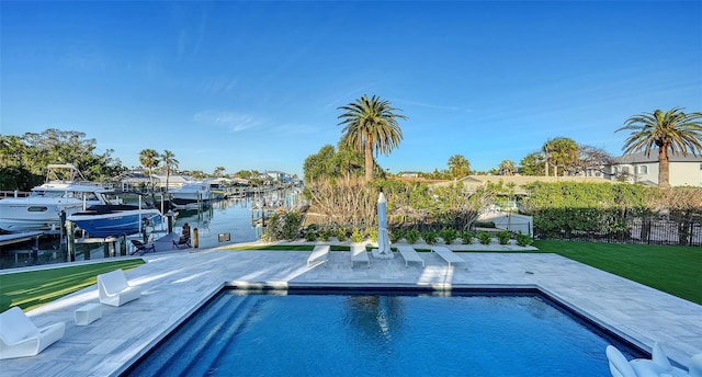 view of pool featuring a patio, a water view, a boat dock, and a lawn