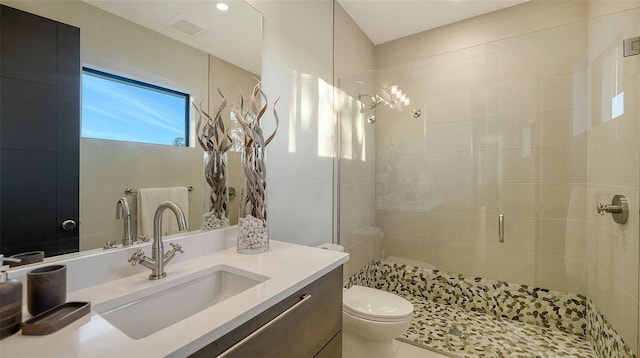 bathroom featuring vanity, tile patterned flooring, toilet, and walk in shower