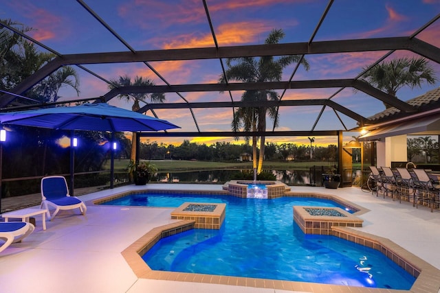 pool at dusk featuring an in ground hot tub, a water view, exterior bar, and a patio