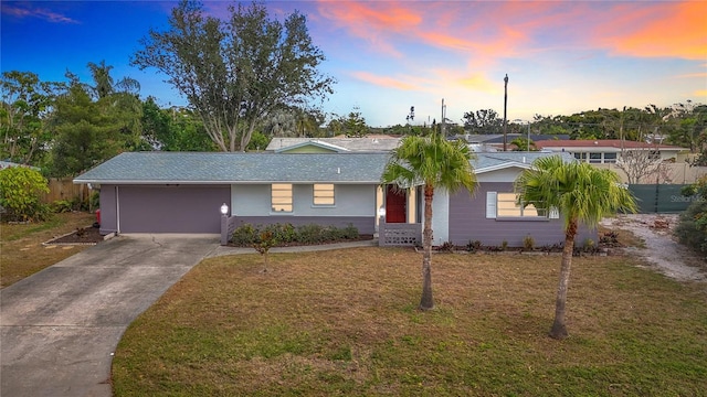 single story home featuring a garage and a yard