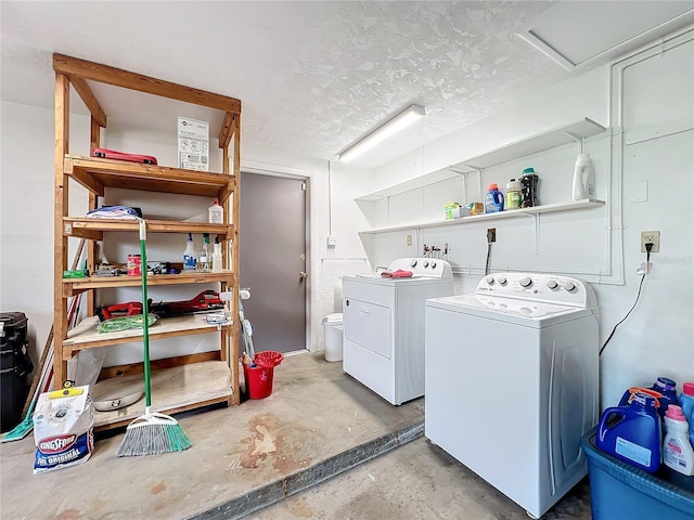 laundry room with a textured ceiling and washer and dryer