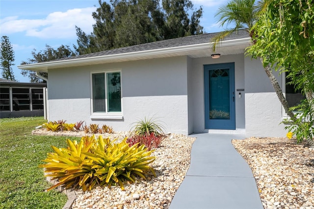 property entrance with a lawn