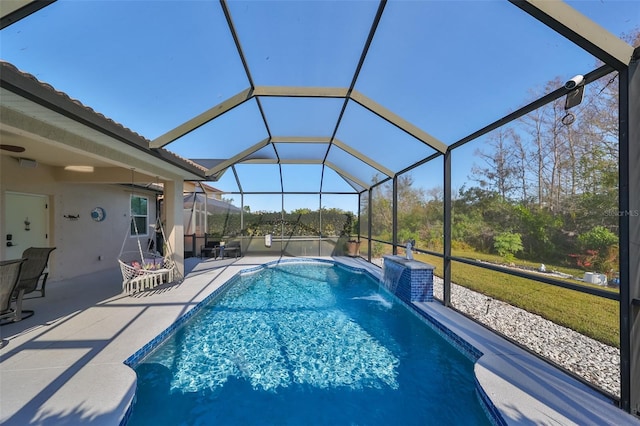 view of pool featuring pool water feature, a patio area, and glass enclosure