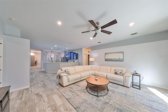 living room with light wood-type flooring and ceiling fan