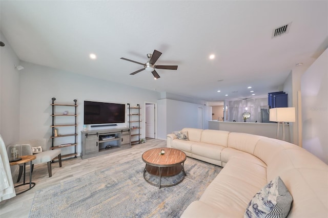 living room with ceiling fan and light wood-type flooring