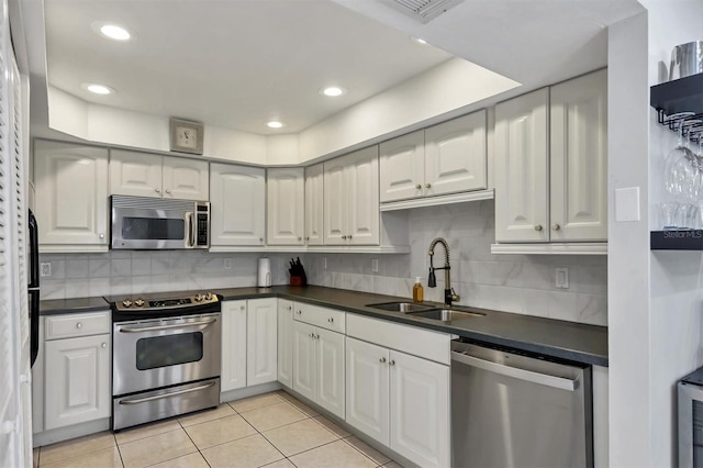 kitchen with light tile patterned floors, sink, white cabinets, and appliances with stainless steel finishes