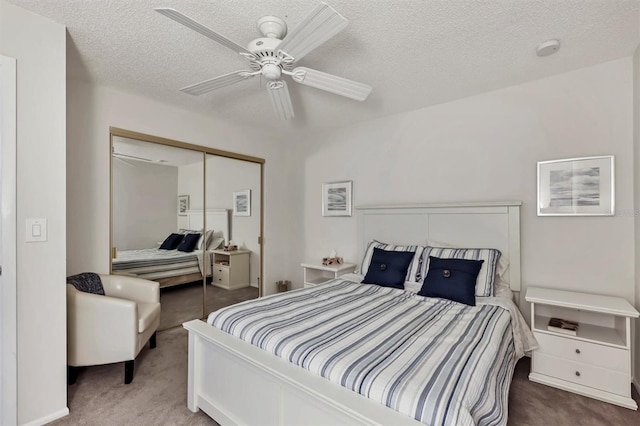 bedroom with ceiling fan, a closet, a textured ceiling, and carpet flooring