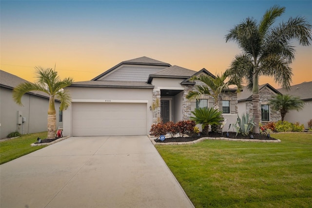 view of front of house featuring a garage and a yard