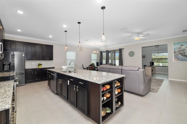 kitchen featuring stainless steel appliances, a kitchen island with sink, hanging light fixtures, ceiling fan with notable chandelier, and sink