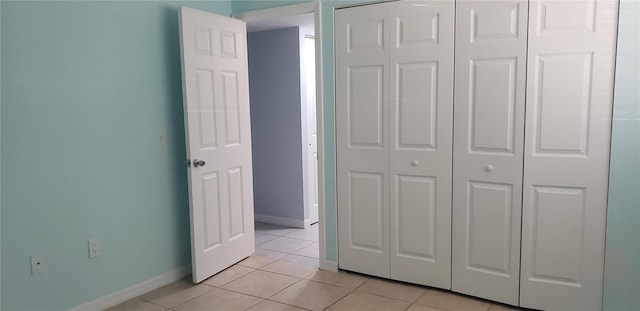 unfurnished bedroom featuring light tile patterned floors and a closet