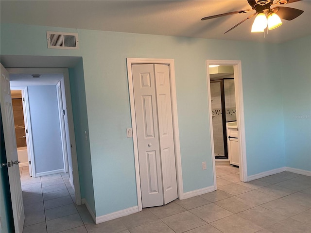 unfurnished bedroom featuring ceiling fan, light tile patterned floors, and a closet