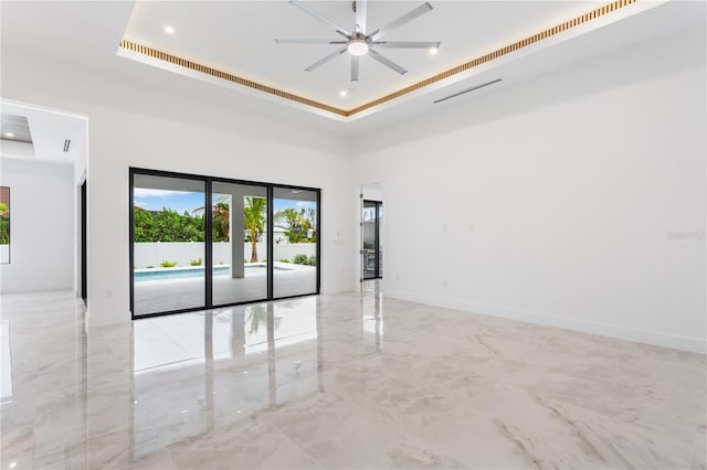 unfurnished room featuring ceiling fan and a tray ceiling