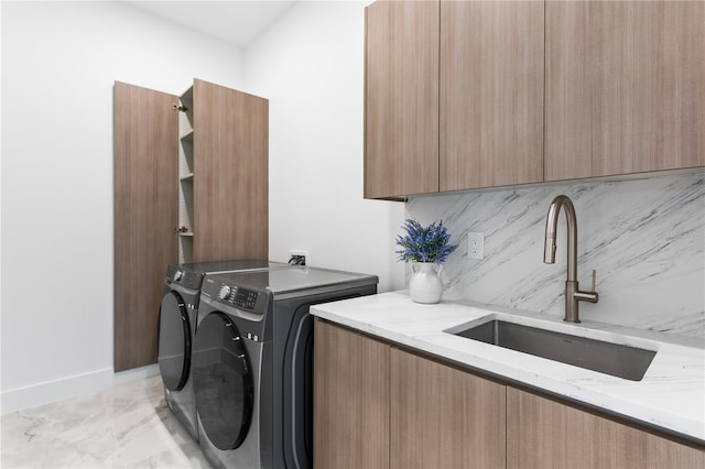 laundry area featuring washer and dryer, cabinets, and sink