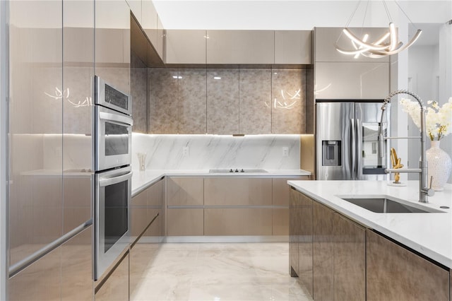 kitchen featuring sink, stainless steel appliances, a chandelier, and decorative light fixtures