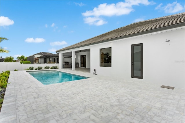 view of swimming pool featuring ceiling fan and a patio